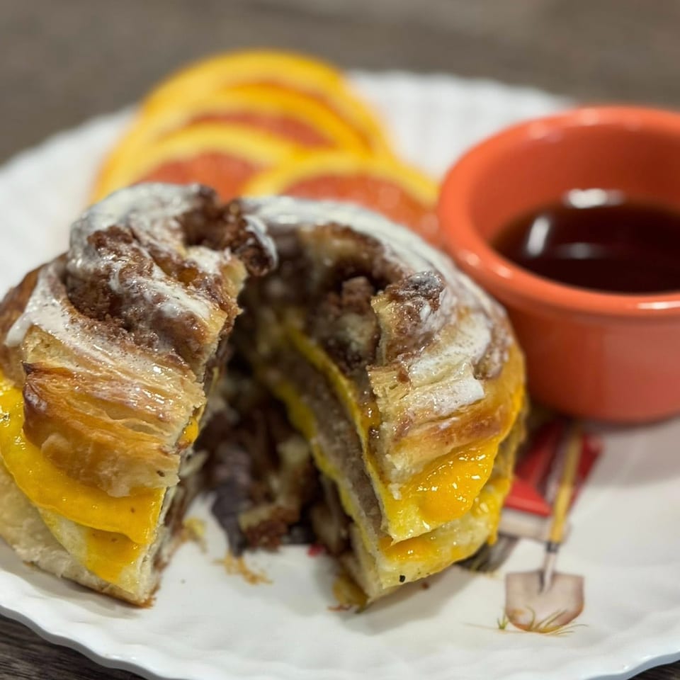 A Molli's Cafe breakfast sandwich, a cinnamon roll sliced in half with egg and cheese inside.